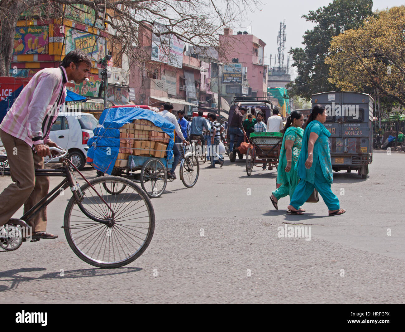 I ciclisti e i pedoni navigazione il traffico in una strada trafficata Chandni Chowk area della Vecchia Delhi, India Foto Stock