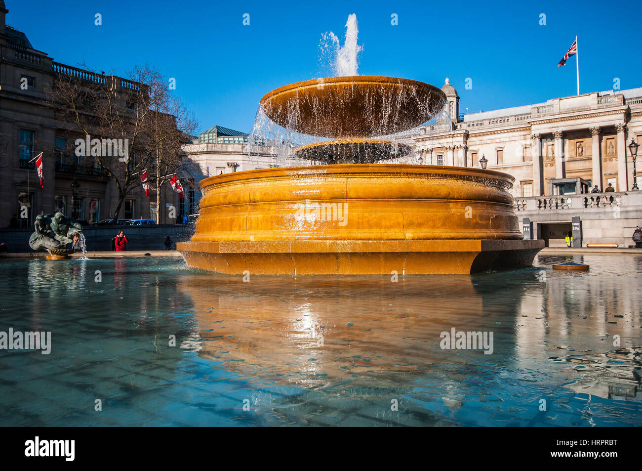 Fontana a Trafalgar Square, Londra, Regno Unito, con ghiaccio sull'acqua in inverno. Cielo azzurro e nitido Foto Stock