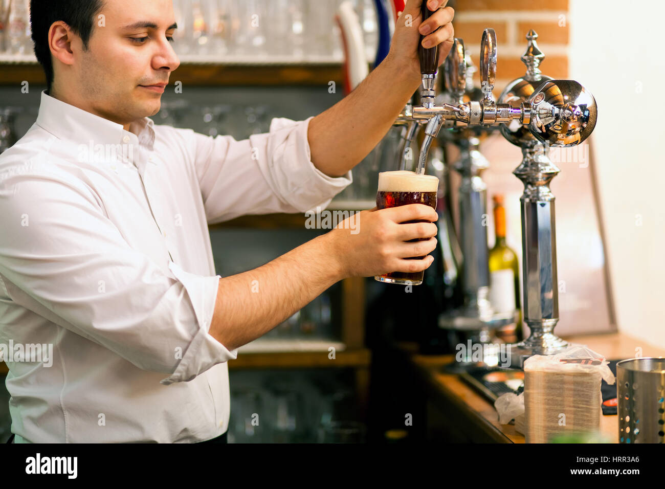 Dettaglio di un barman il disegno di una birra Foto Stock