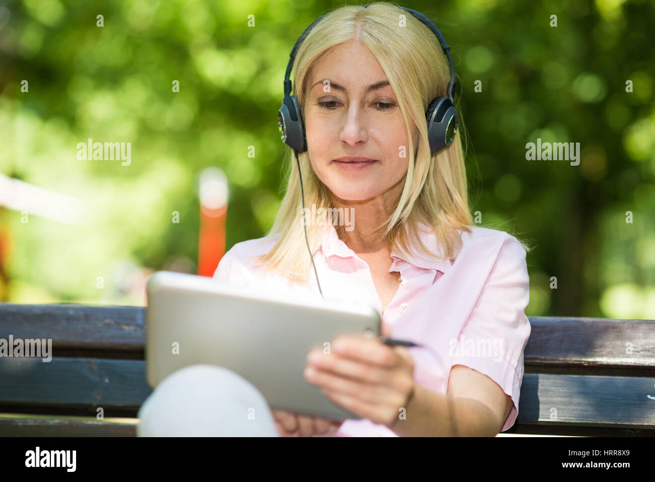 Ritratto di una donna matura ascoltando musica all'aperto Foto Stock