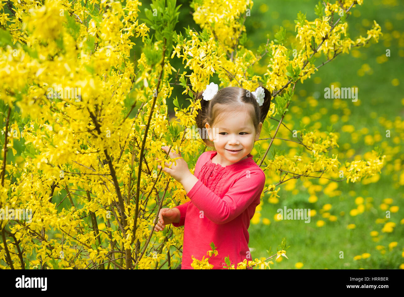 Carino funny girl di quattro anni a giocare allegramente fuori in primavera soleggiata città park. Orizzontale fotografia a colori. Foto Stock