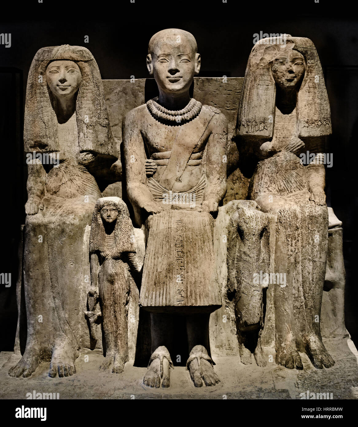 La scultura del XIX dinastia, Saqqara, testimonianza dell'epoca di Ramses II (1303 - 1213). Sulla parte anteriore del quadro, Ptahmai siede tra la moglie Hatshepsut andhis Iniuhaj figlia. La figura centrale è Ptahmai, che è calvo con una doppia catena di remi di oro e perle di cordone intorno al collo. Le due catene punto per i suoi meriti militari, probabilmente durante il vittorioso guerre del faraone Ramses II. Dopo il suo tempo di militari, Ptahmai Wab sacerdote di Ptah è stato raffigurato con la testa rasata secondo la purezza del sacerdozio. Foto Stock