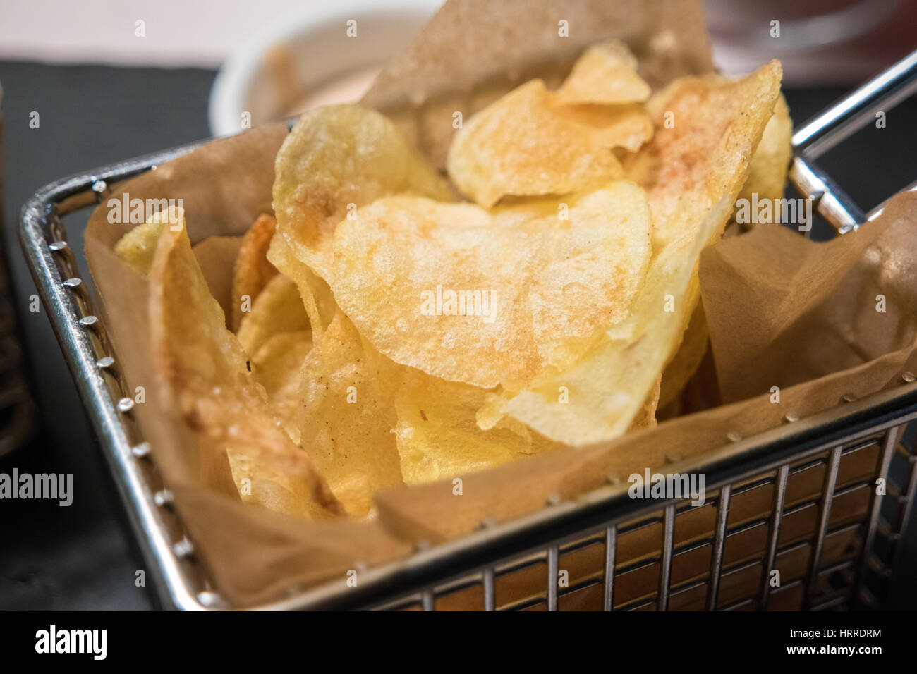 Dettaglio del profondo fritto Patatine serviti in un metallico Cestello friggitrice Foto Stock