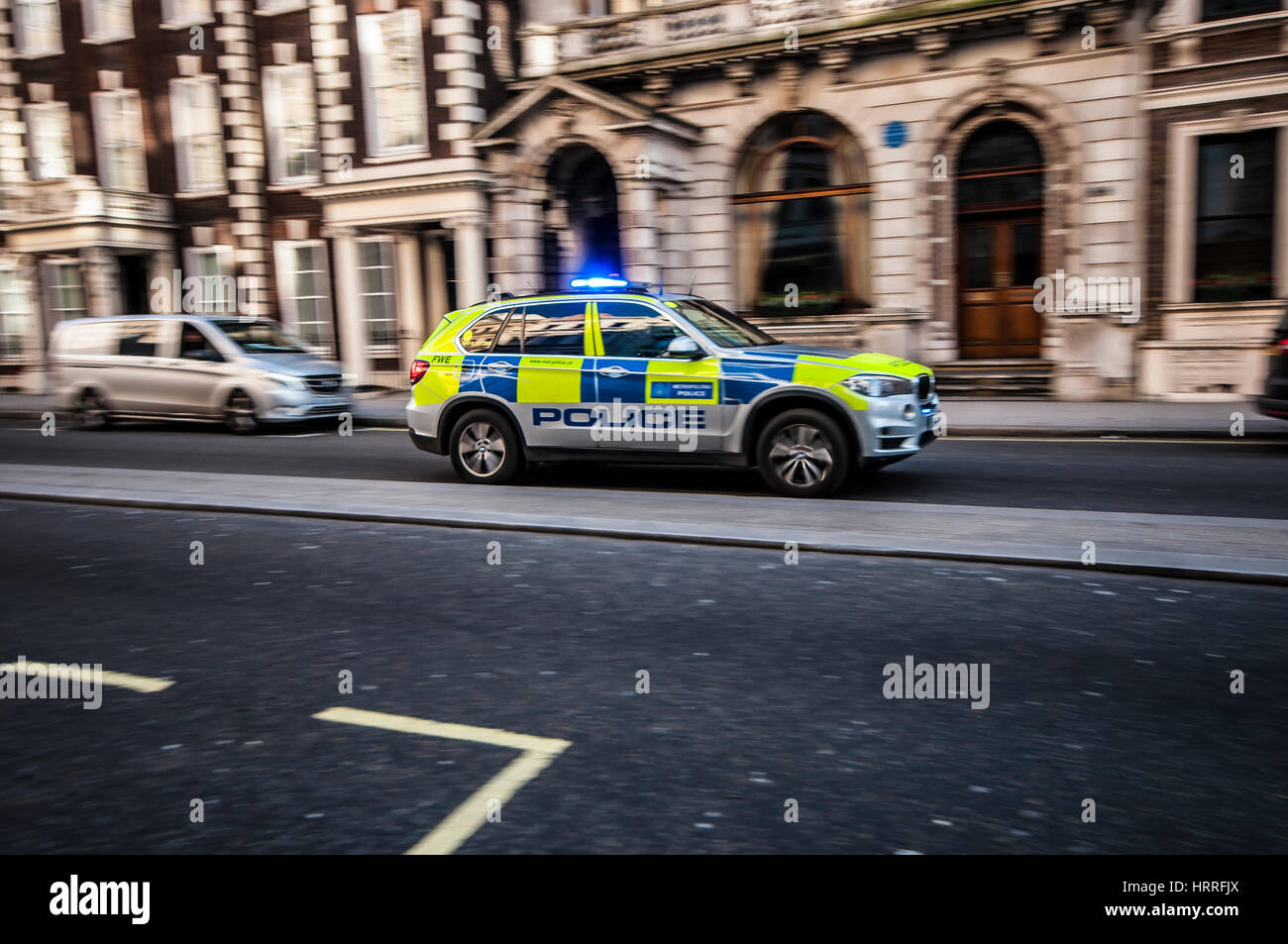 Un'auto della polizia che viaggia a velocità elevata attraverso Londra con luci blu lampeggianti Foto Stock