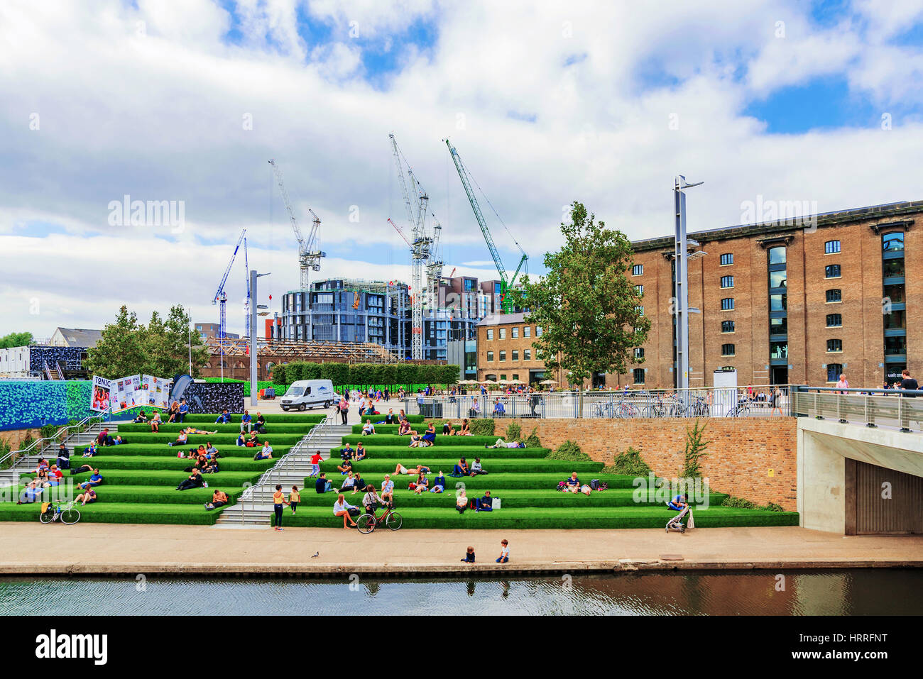 Londra - 22 agosto: questa è una vista del granaio Piazza con gente seduta riverside lungo il Regents Canal e il Central Saint Martins University ca Foto Stock