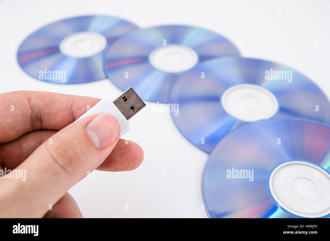 Mano azienda unità USB. Dischi DVD in background Foto Stock