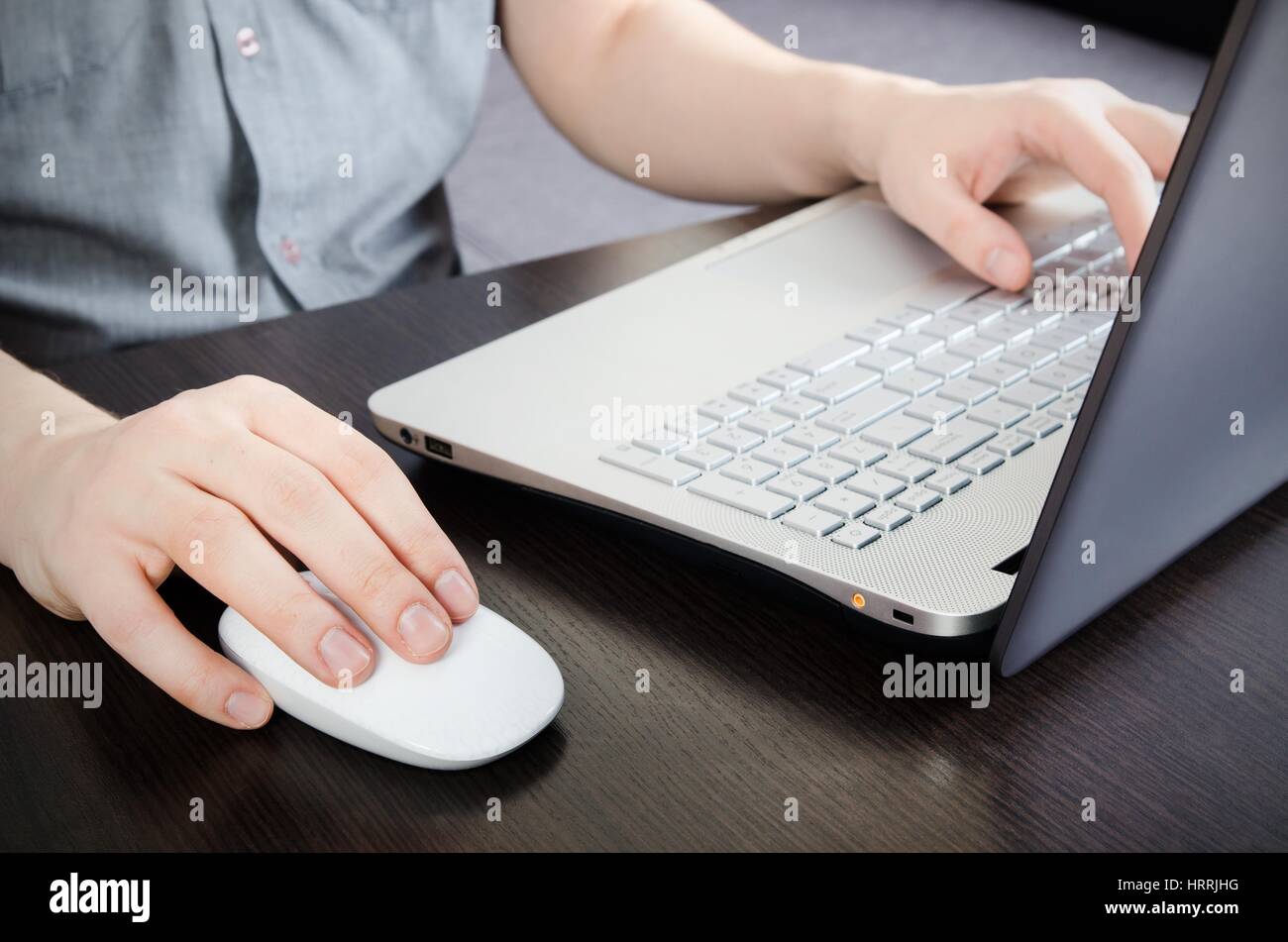 Uomo che lavora in ufficio. Computer portatile con white keyboard e mouse bianco Foto Stock