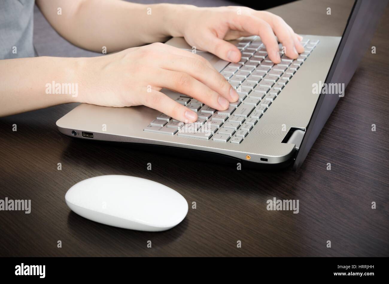 Uomo che lavora in ufficio. Computer portatile con white keyboard e mouse bianco Foto Stock