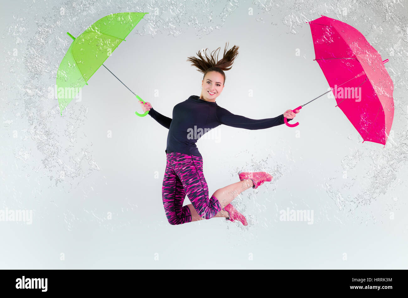 Donna in salto con un ombrello. Movimento congelato. Foto Stock