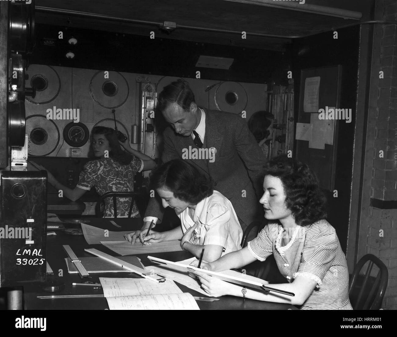 Un supervisore maschio guarda oltre il lavoro di alcune donne 'computer umano', 1945. Immagine cortesia della NASA. Foto Stock