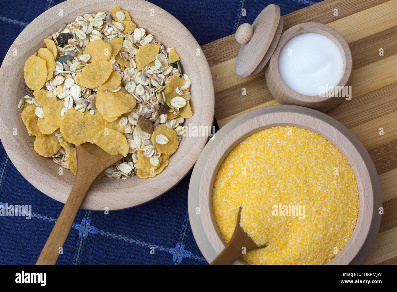 Sale in una piccola ciotola di legno posto sul piatto di legno con i cereali e la farina di mais Foto Stock