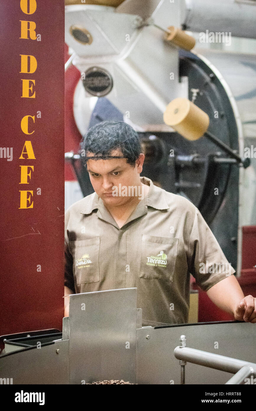 Un lavoratore è la tostatura i chicchi di caffè in un impianto di San Marcos, Costa Rica. Foto Stock
