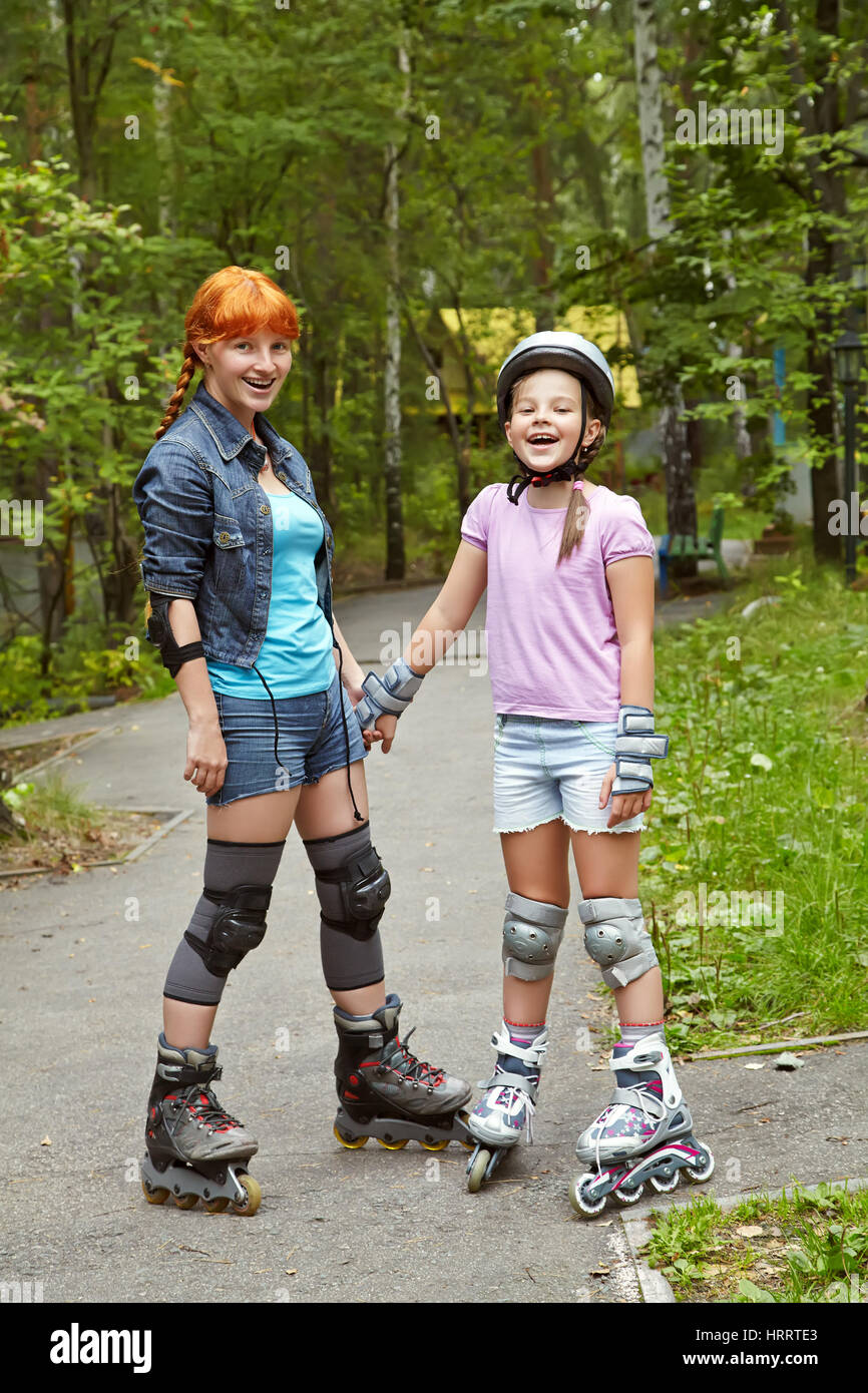 Sport La madre e la figlia in un casco. famiglia sui pattini. Due persone rollerblade. rollerskating outdoor Foto Stock