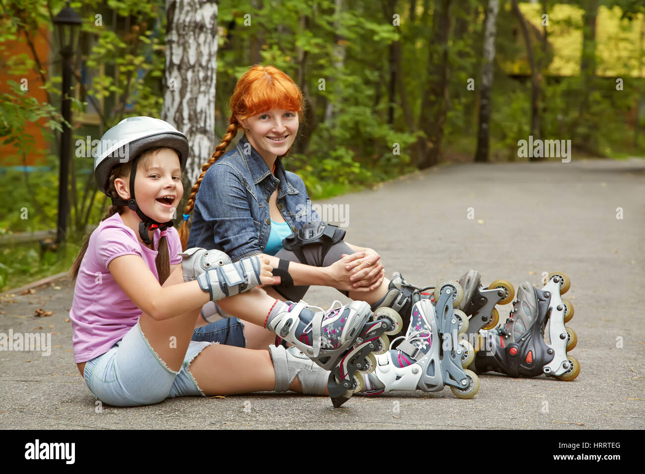 Sport La madre e la figlia in un casco. famiglia sui pattini. Due persone rollerblade. rollerskating outdoor Foto Stock
