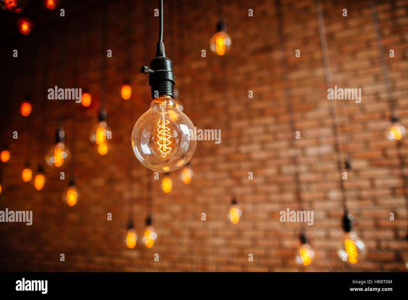 Lampadina a filamento Edison retro vintage decore sul muro di mattoni in background. Decorazione di illuminazione Foto Stock