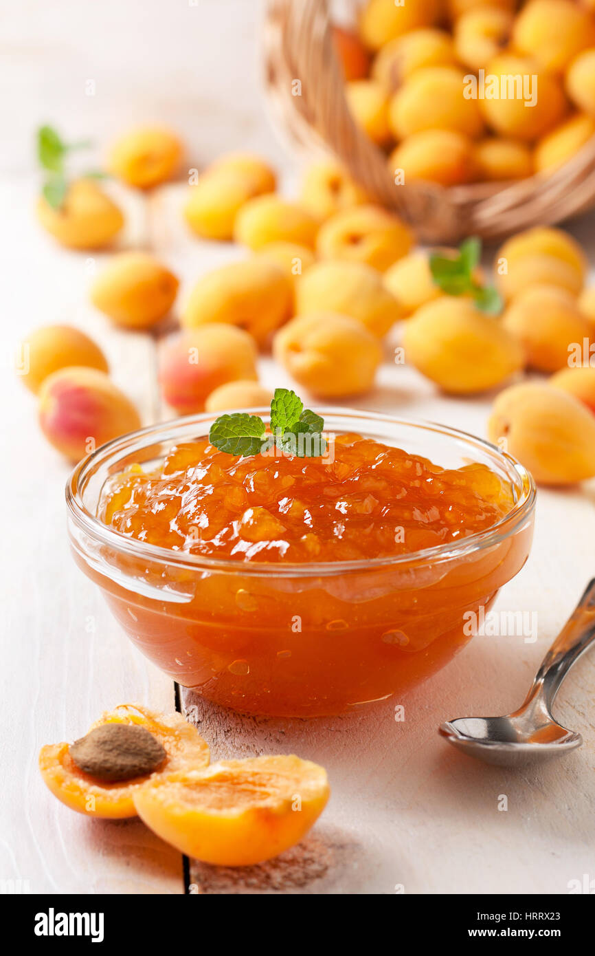 Confettura di albicocche in una ciotola di vetro , fresche Albicocche su sfondo di legno Foto Stock