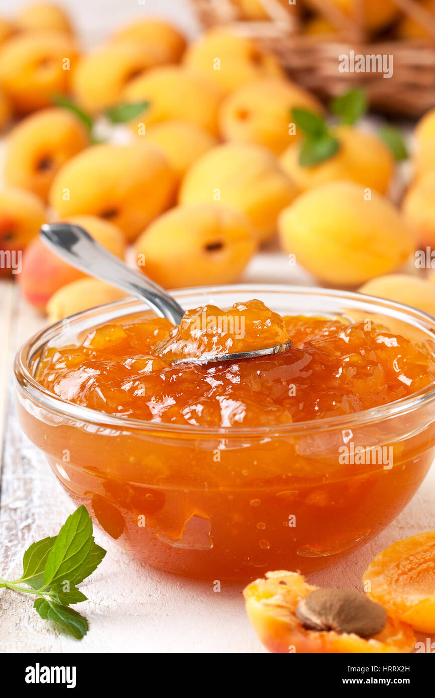 Confettura di albicocche in una ciotola di vetro , fresche Albicocche su sfondo di legno Foto Stock