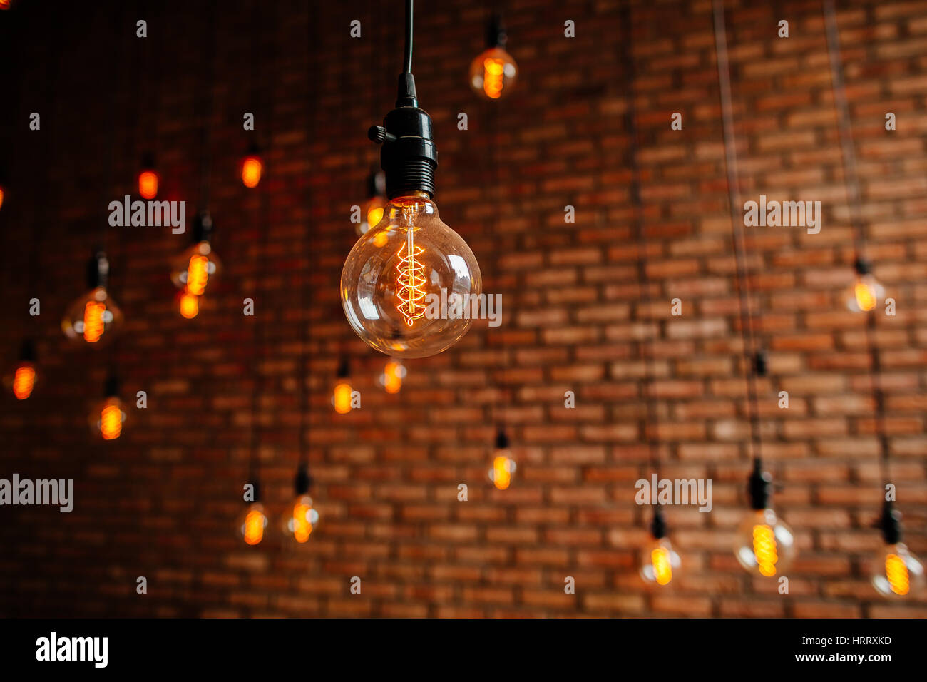 Lampadina a filamento Edison retro vintage decore sul muro di mattoni in background. Decorazione di illuminazione Foto Stock