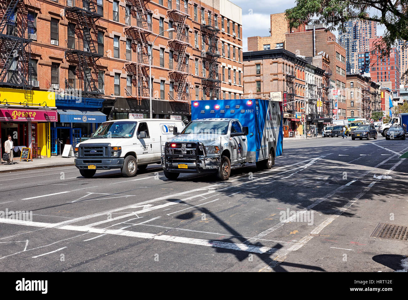 NEW YORK CITY - 26 settembre 2016: Ambulanza con luce di emergenza e un piccolo camion sulla 9th Avenue e la 51st W Street in Hell's Kitchen su Manhattan Foto Stock