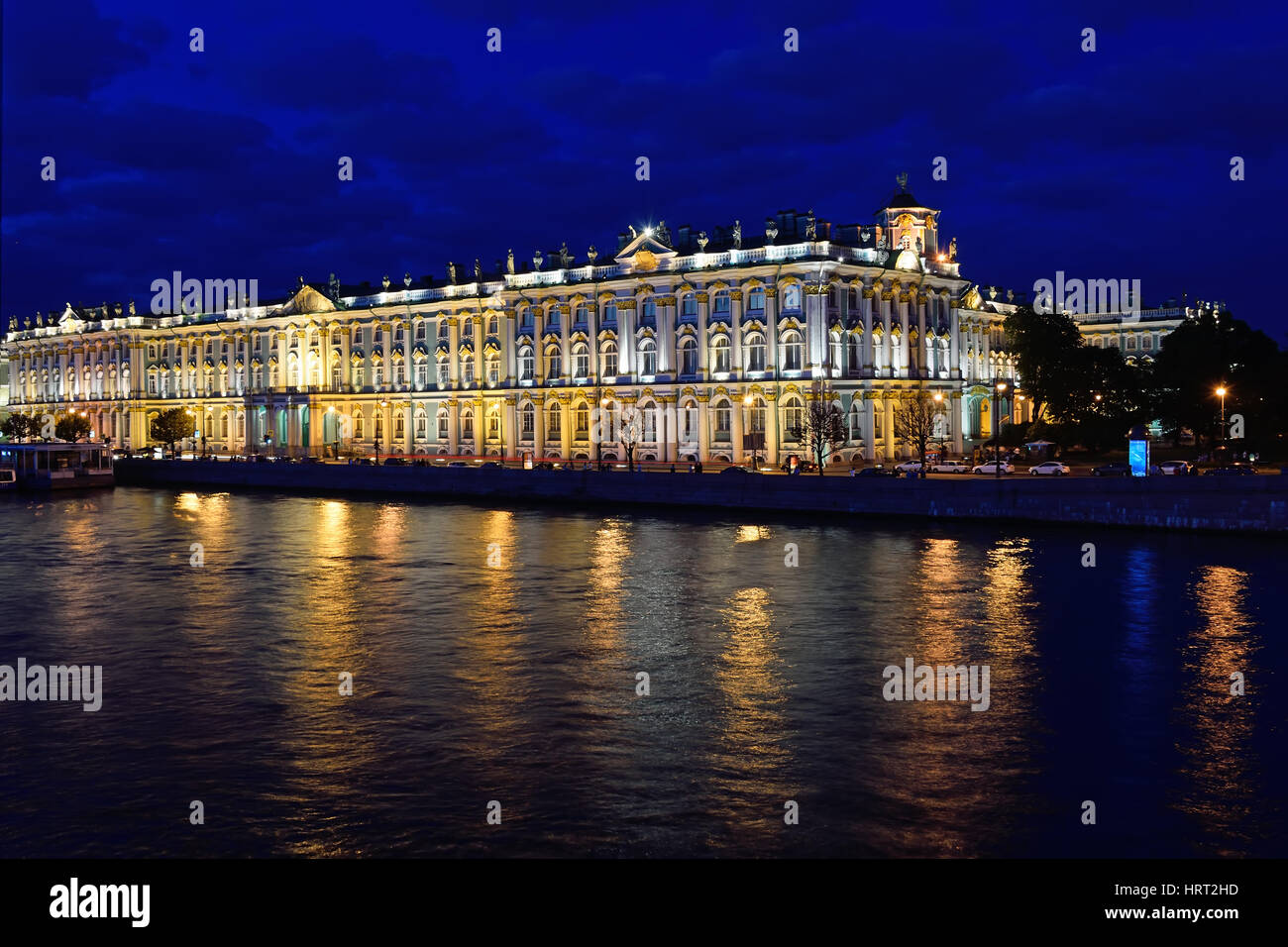 Vista del Palazzo d'inverno dal palazzo ponte sul fiume Neva durante le notti bianche a San Pietroburgo. Nel fiume riflette le luci della strada Foto Stock