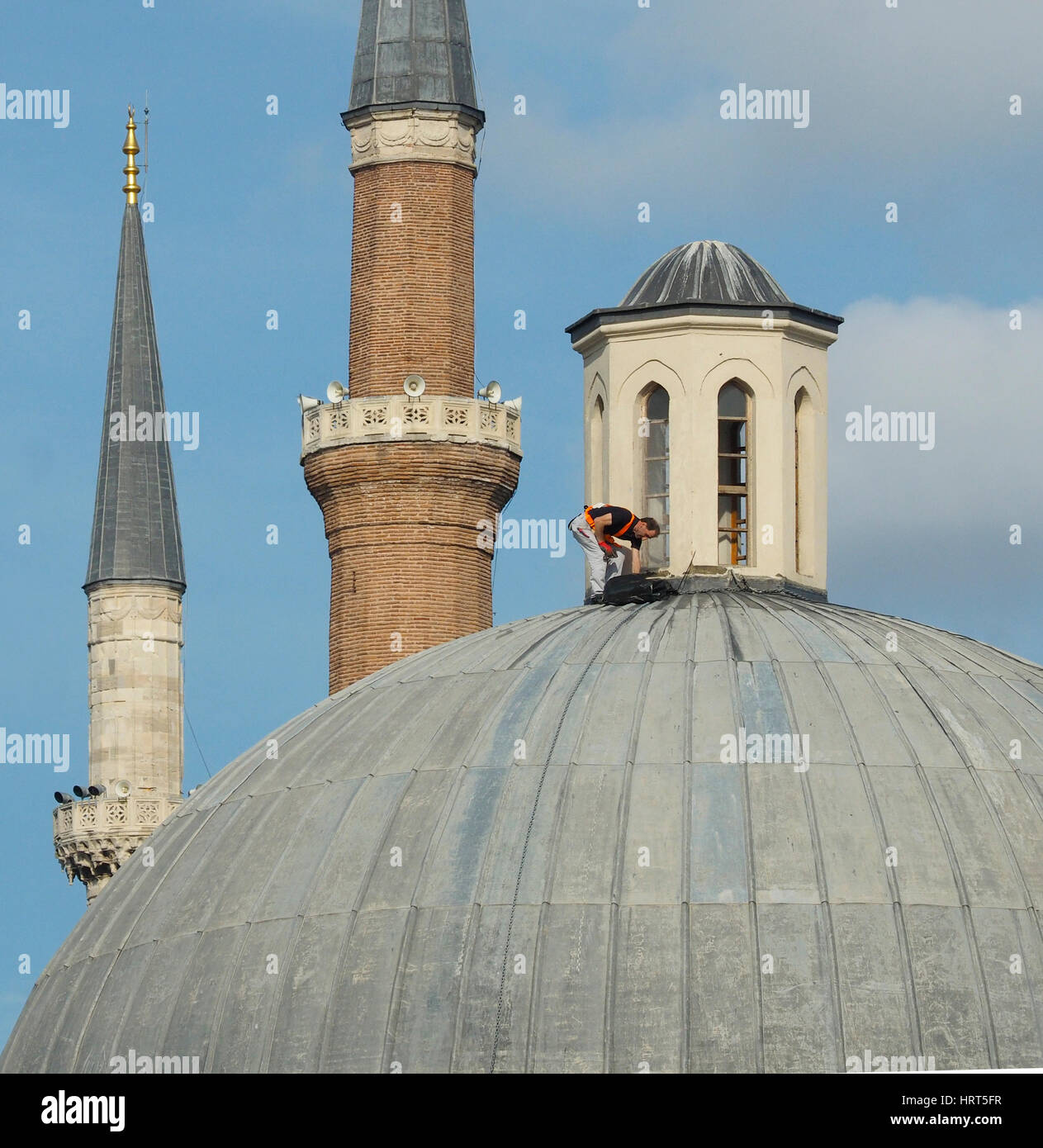 Lavoratore di manutenzione sul tetto a cupola con cablaggio di sicurezza senza casco area di Sultanahmet vicino Hagia Sophia Istanbul TURCHIA Foto Stock