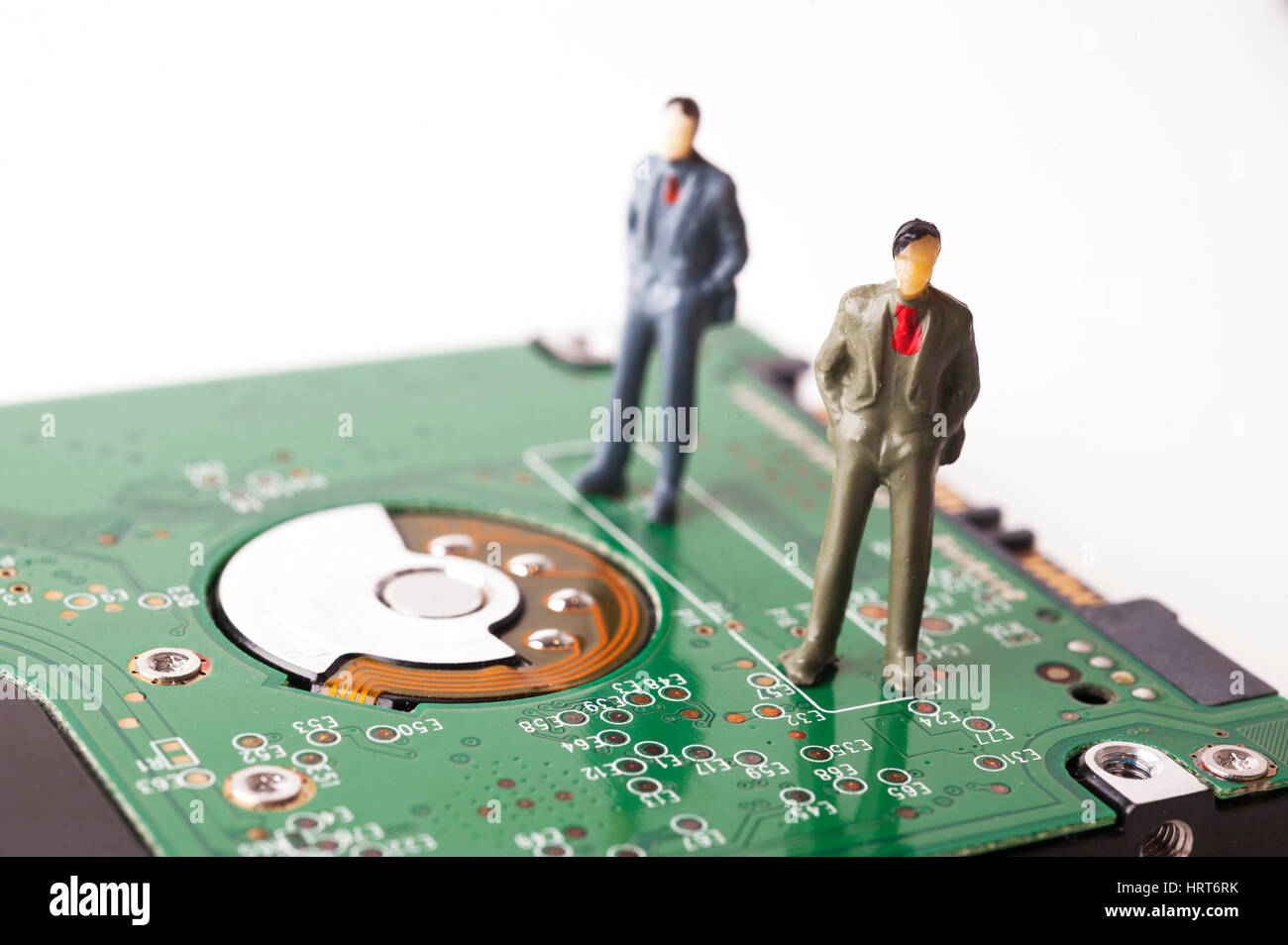 Statuine in miniatura di due uomini stavano in piedi su unità disco rigido del computer Foto Stock