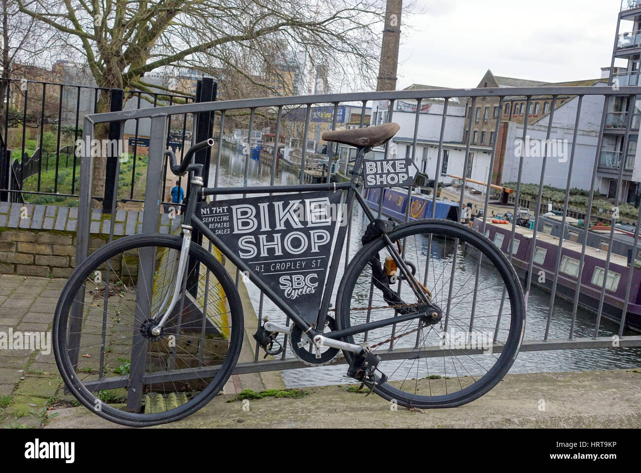 Bicicletta sul ponte sul canale di pubblicità bike shop a Islington, Londra Foto Stock