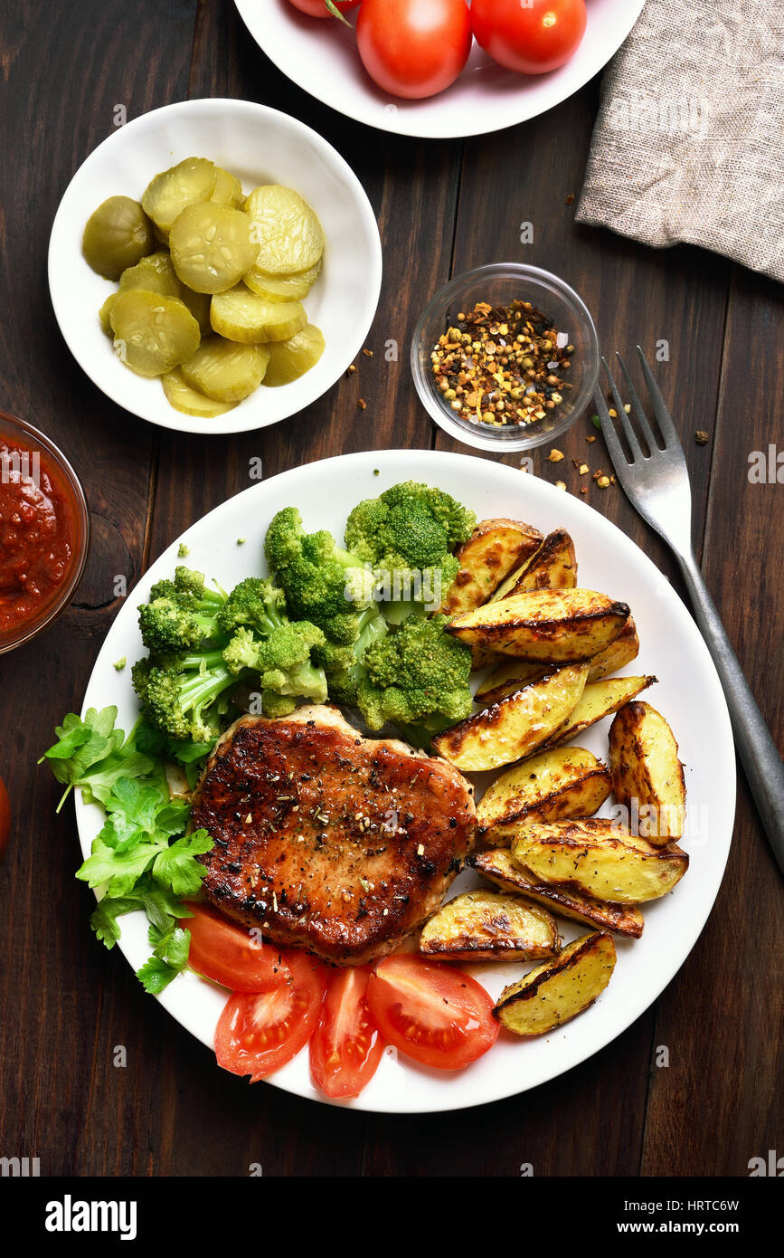 Grigliate di carne e verdure, piatto per la cena su sfondo di legno, vista dall'alto Foto Stock