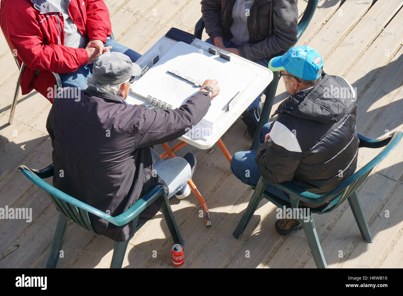 Barcellona, Spagna - 01 Marzo 2016: quattro uomini anziani giocando a un gioco di domino a Barceloneta Beach. Foto Stock