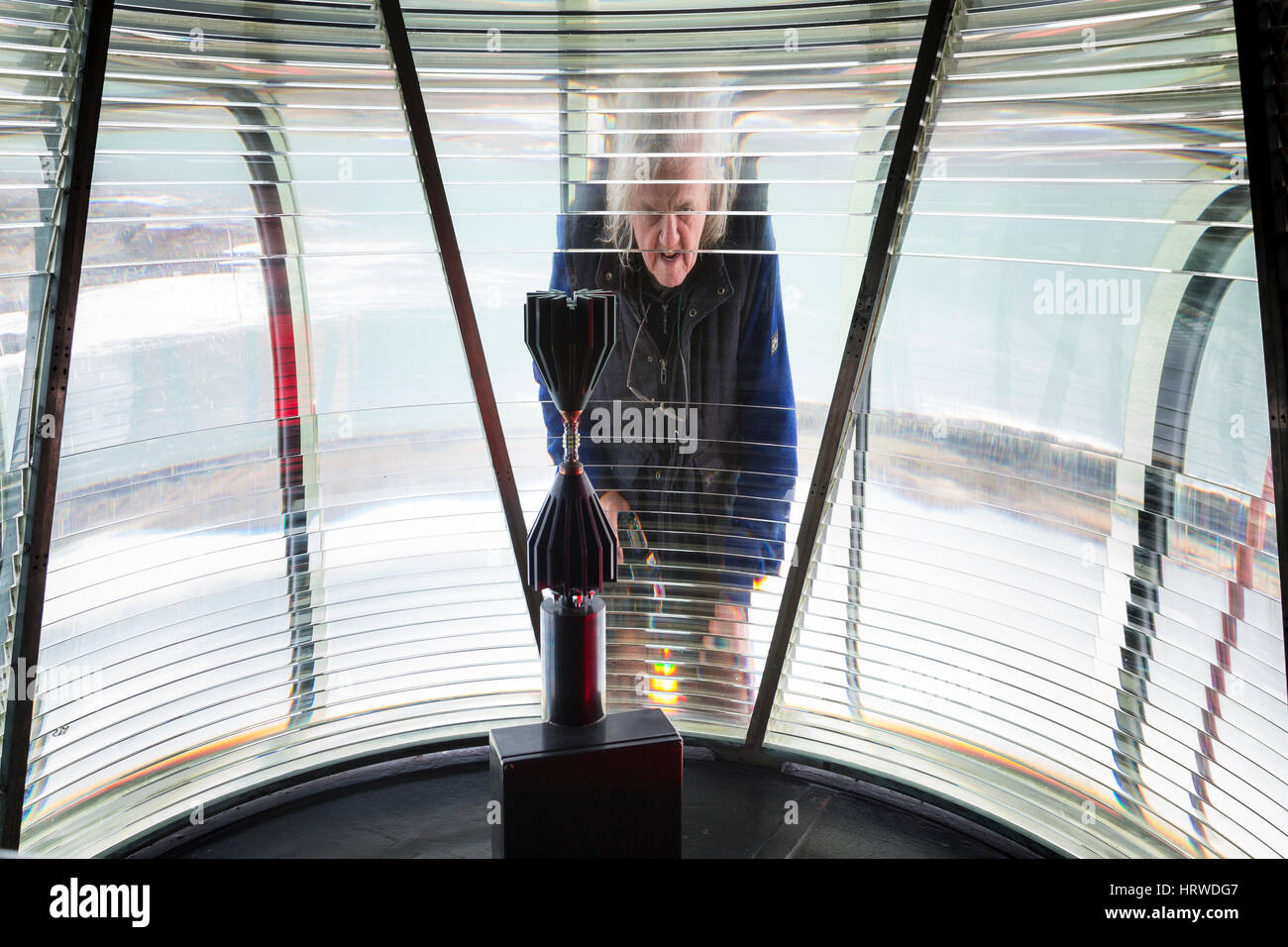 La riflessione di un uomo in una schermata di Fresnel a Faro, Valentia Island, nella contea di Kerry, Irlanda Foto Stock