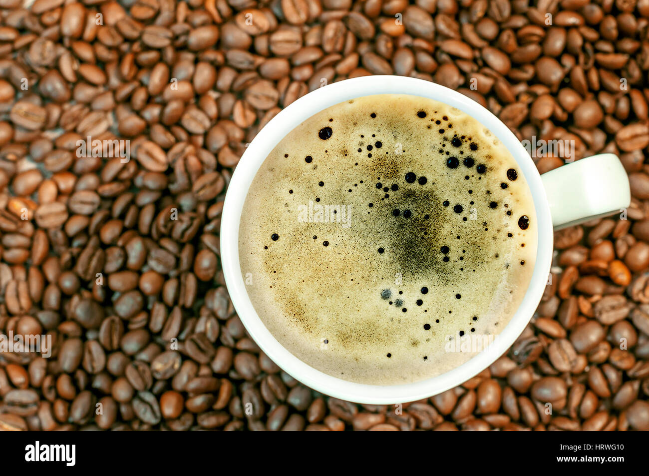 Chicco di caffè sfondo con tazza di caffè caldo vicino Foto Stock