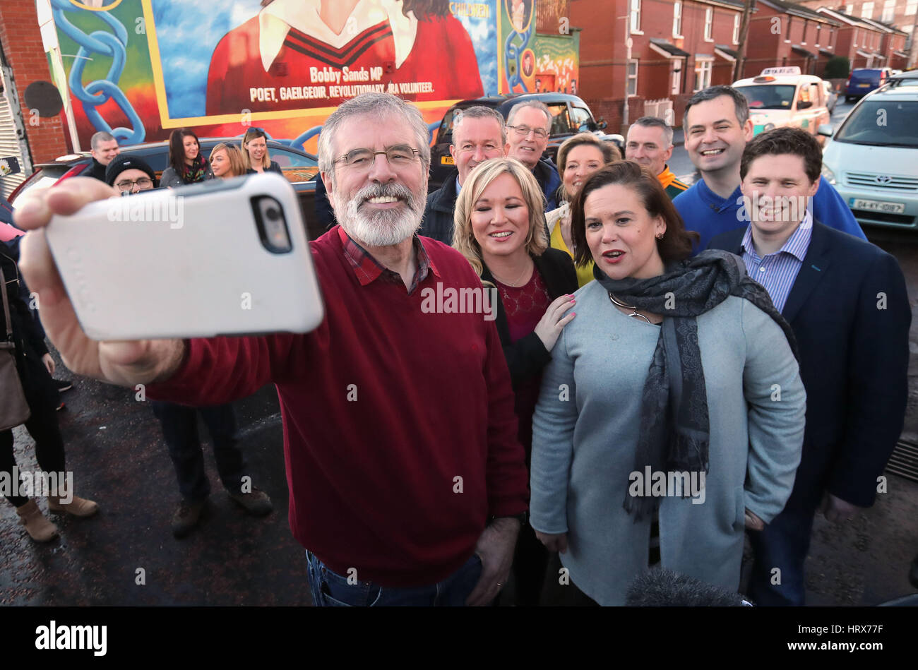 Michelle O'Neill, leader del Sinn Fein in Irlanda del Nord (al centro) con Sinn Fien Presidente Gerry Adams (sinistra) prendendo un selfie al di fuori del Sinn Fein sede a Belfast. Foto Stock