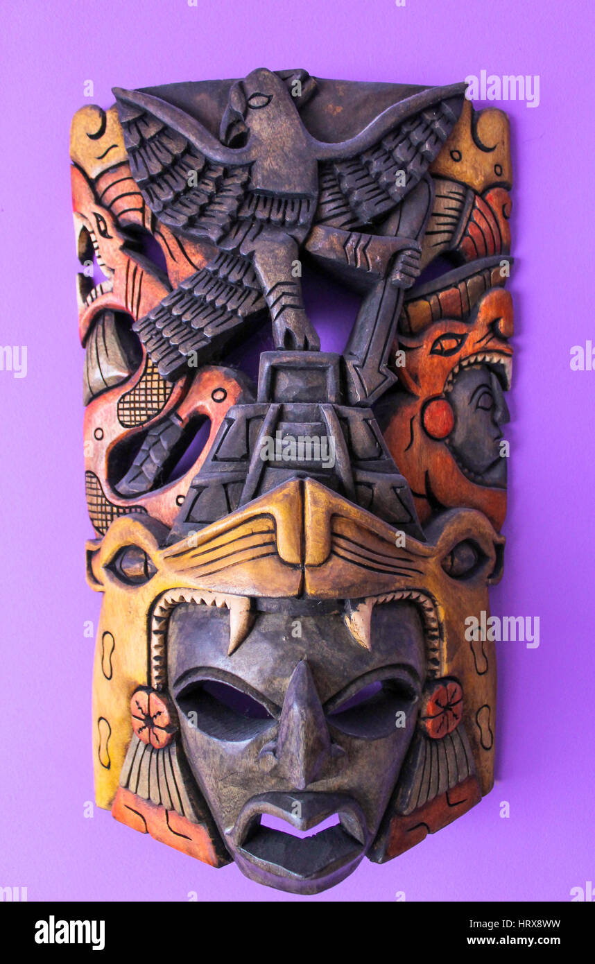 Immagine di un africano maschera di legno su una parete di porpora, tribal design in legno Foto Stock