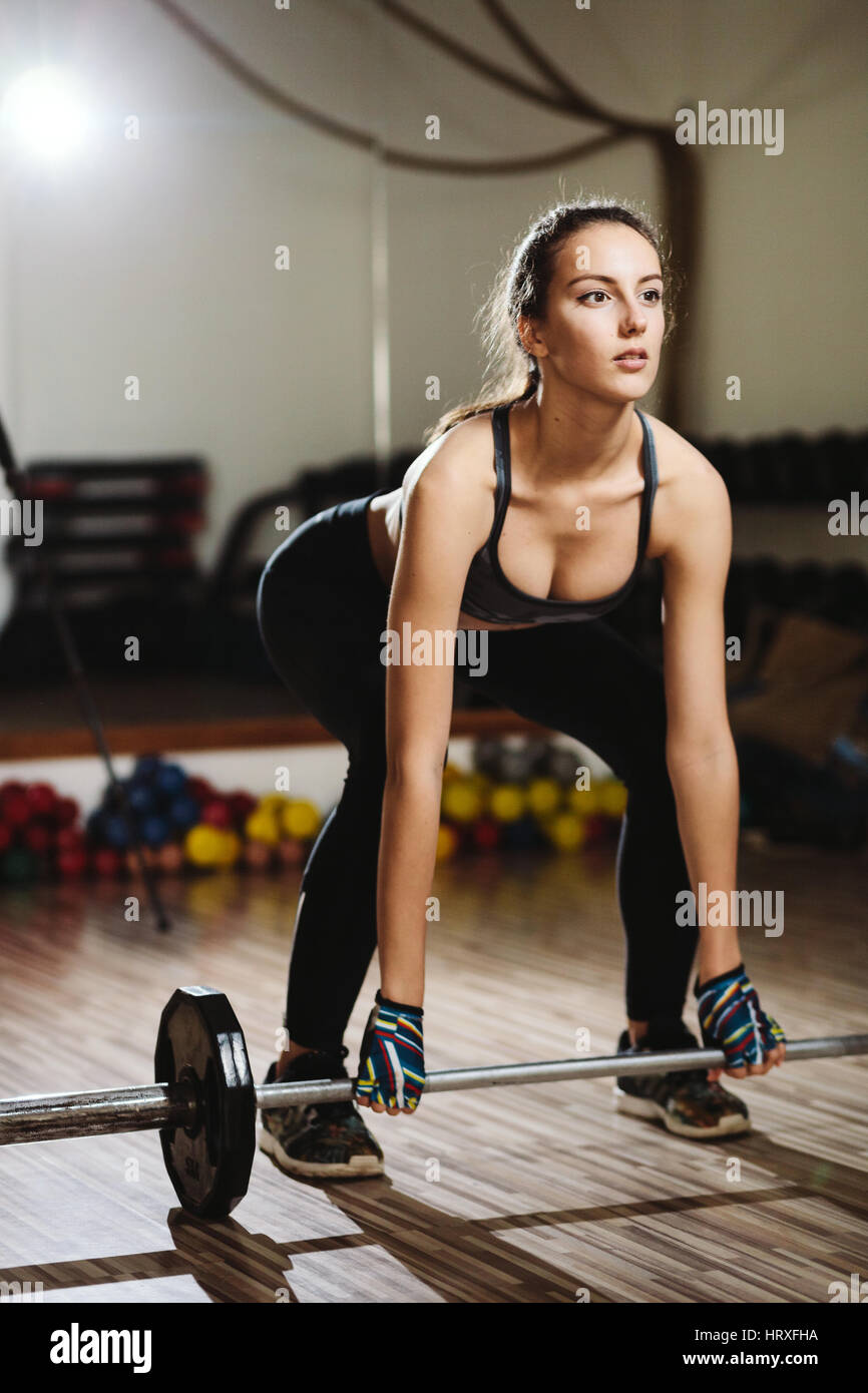 Donna fitness pesi deadlift. Modello di fitness girl il sollevamento pesi in palestra. Foto Stock