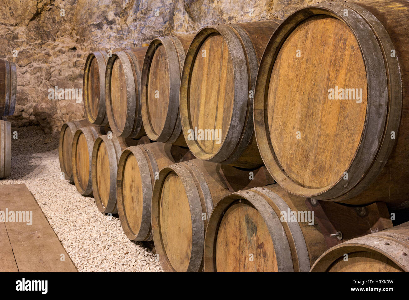 Botti da vino impilati nella vecchia cantina dell'azienda vinicola Foto Stock