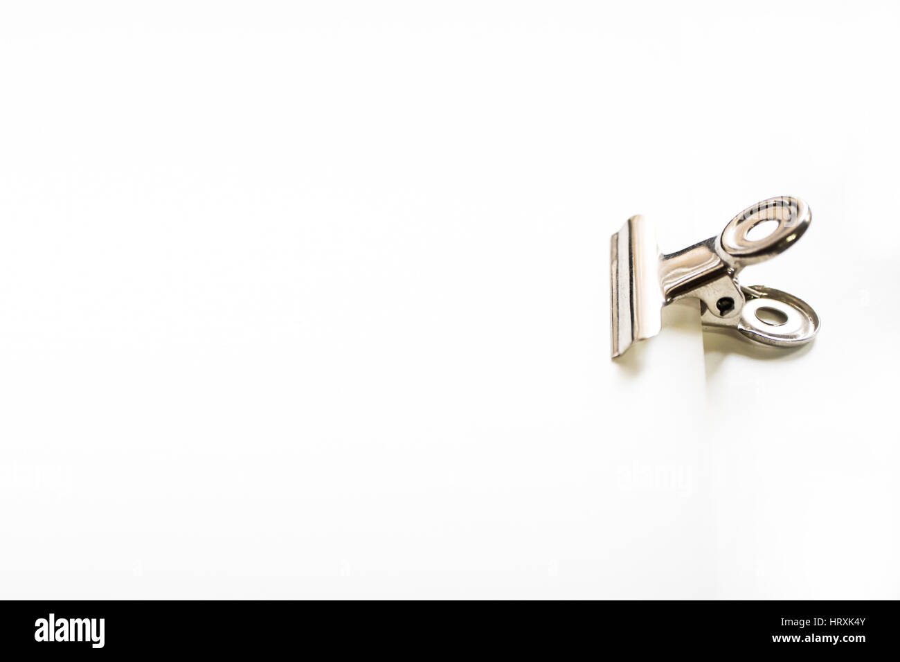 Mano che tiene fermo sulla tela bianca della carta. Foto Stock