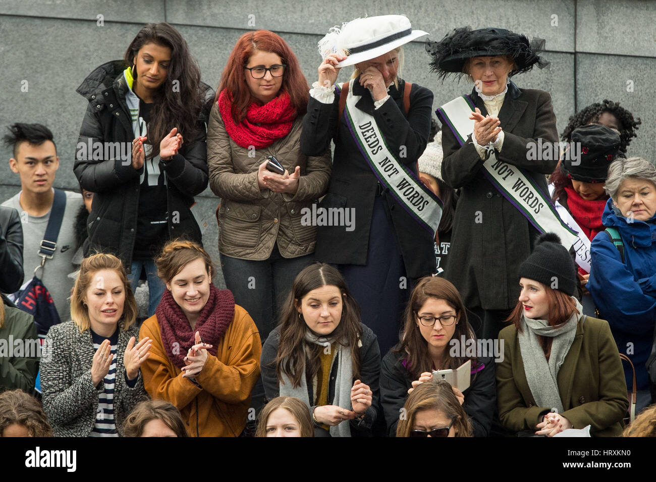Le donne nel periodo delle suffragette dress tra la folla al convogliatore, vicino al Tower Bridge di Londra, che prendono parte a marzo4Donne in vista della Giornata internazionale della donna. Foto Stock