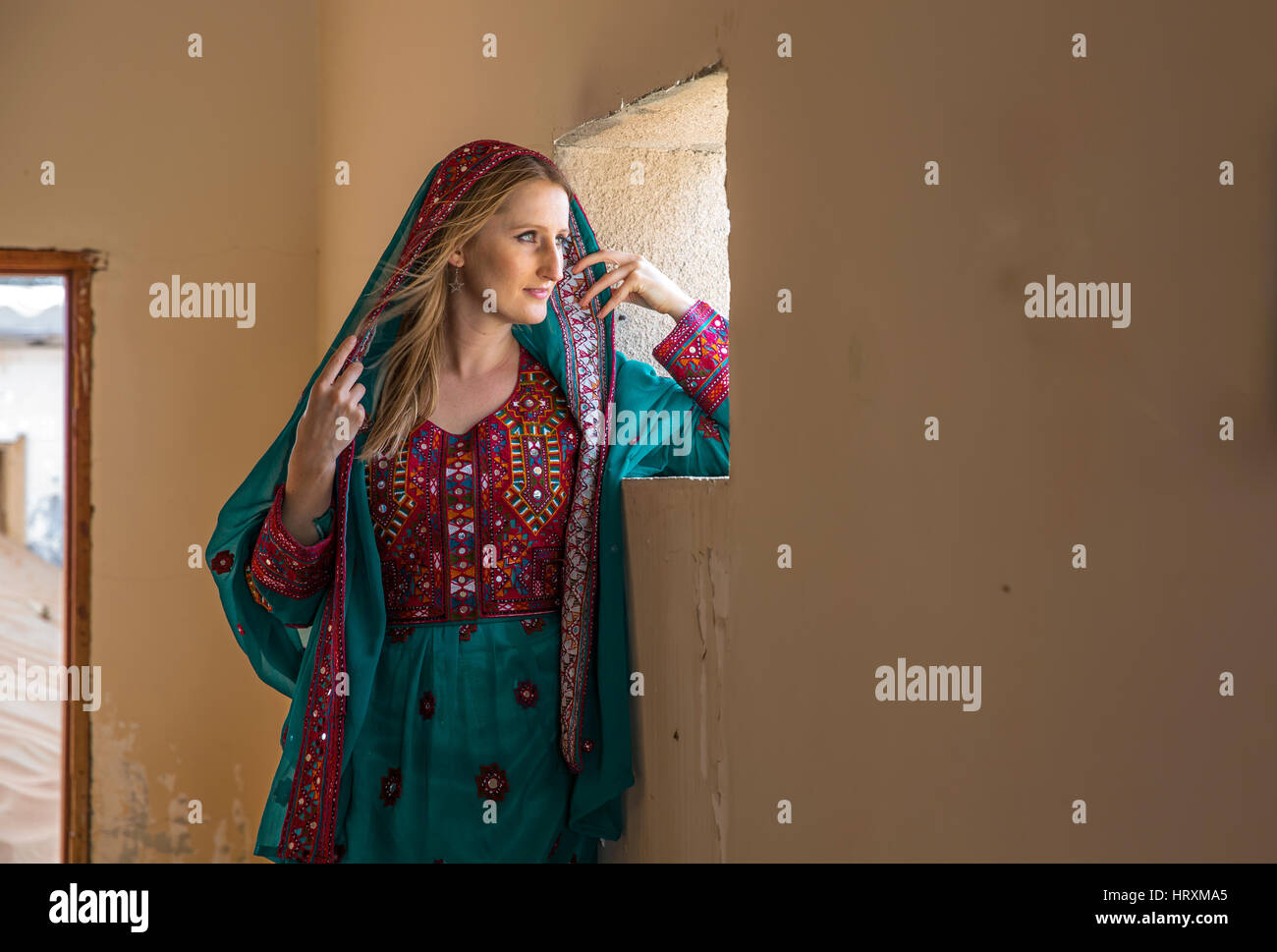 Una donna in tradizionali Omani vestito in un villaggio abondoned in un deserto Foto Stock