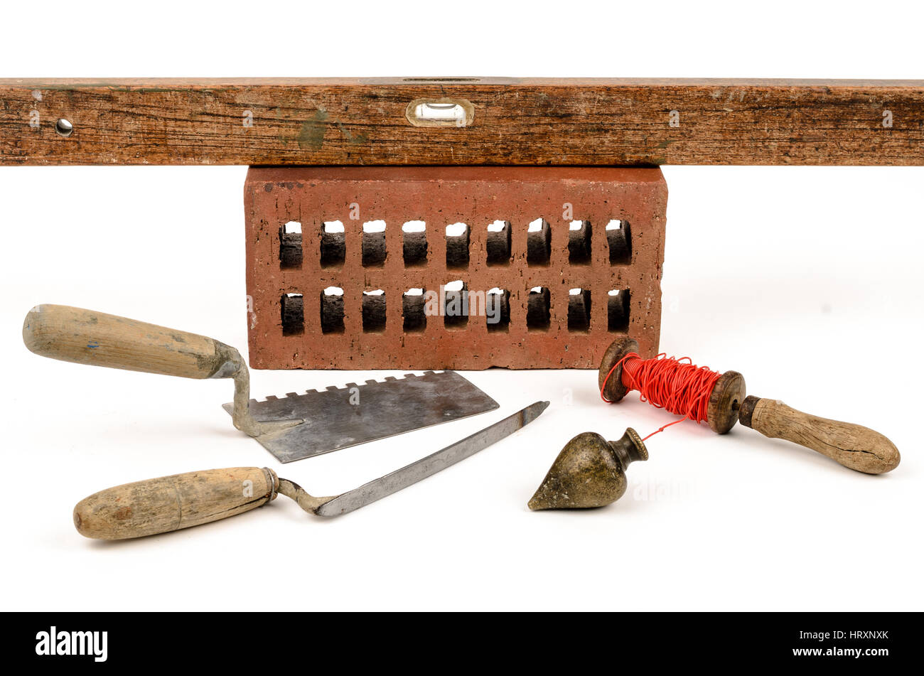 Vecchia costruzione accessori cazzuola, mattoni, Piombino e il livello di sfondo bianco. Foto Stock