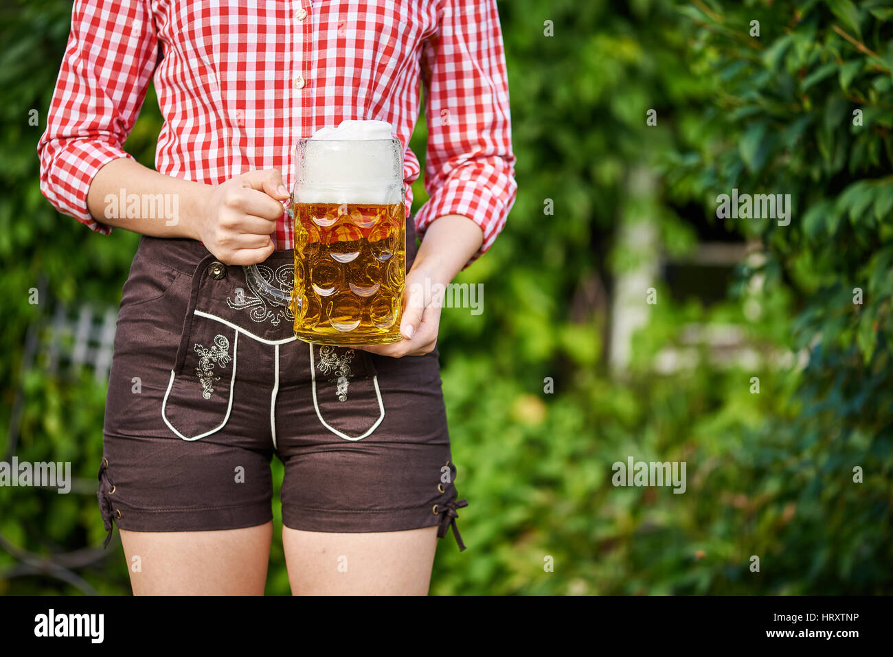 Donna con pantaloni di pelle e boccale di birra Foto Stock