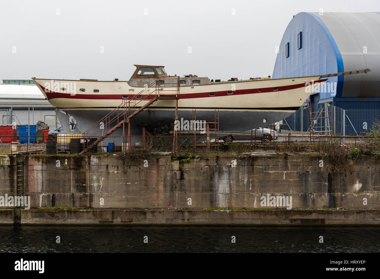Barca nel bacino di carenaggio sulla Baia di Cardiff, Galles, UK. Yacht subendo lavori di riparazione in cantiere Foto Stock