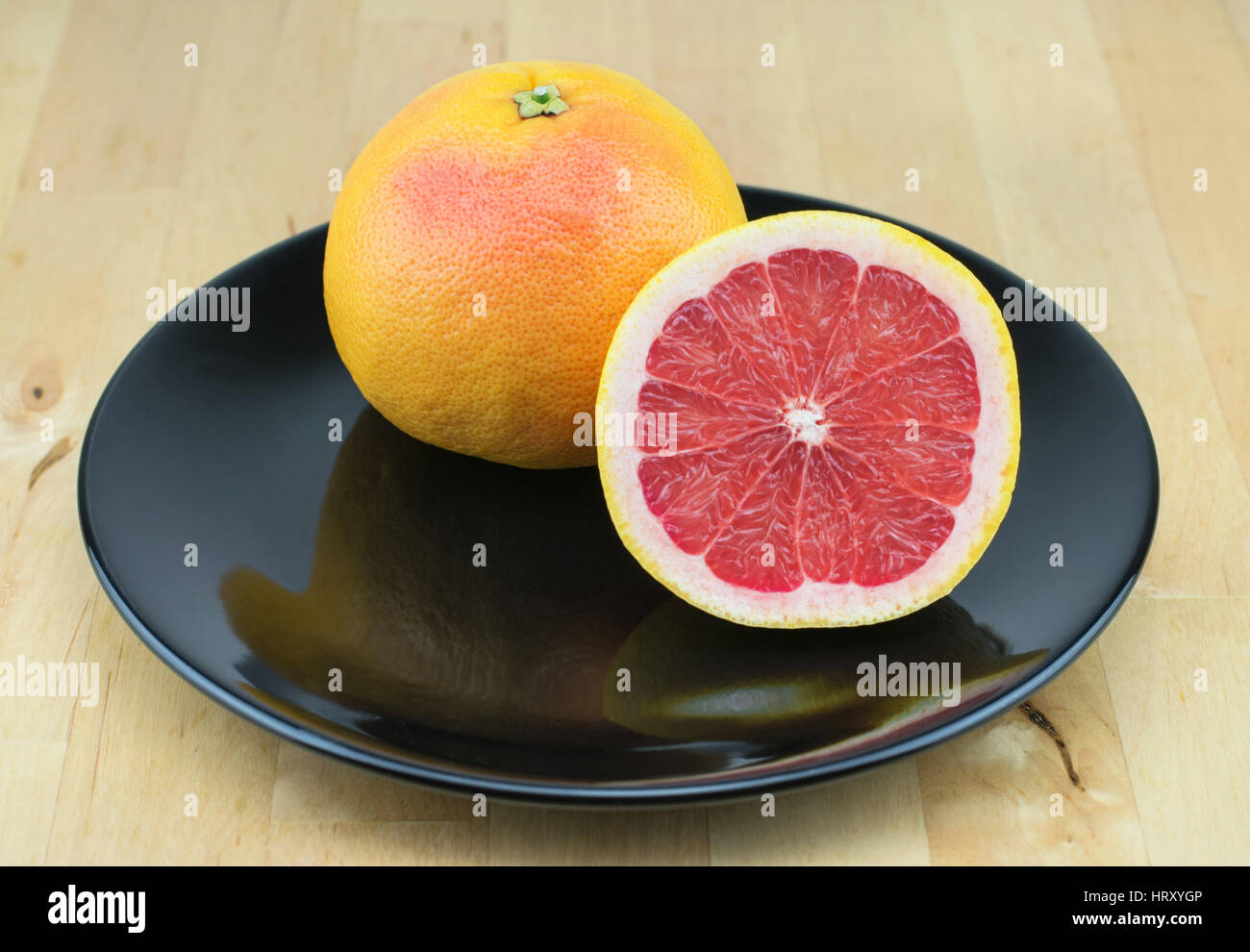 Succosa pompelmo rosso sulla piastra nera. Foto Stock