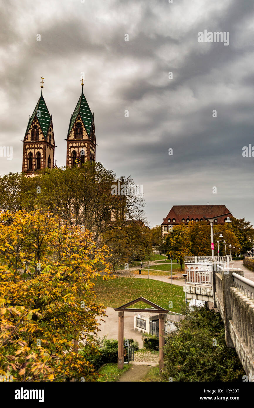 Chiesa con due torri gemelle dalla stazione di Friburgo su nuvoloso novembre mattina. Foto Stock