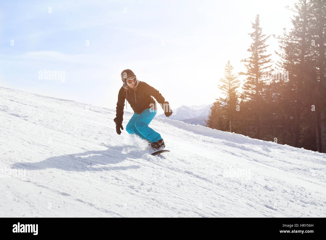 Snowboard attività invernali, snowboarder in discesa su un pendio in montagna Foto Stock