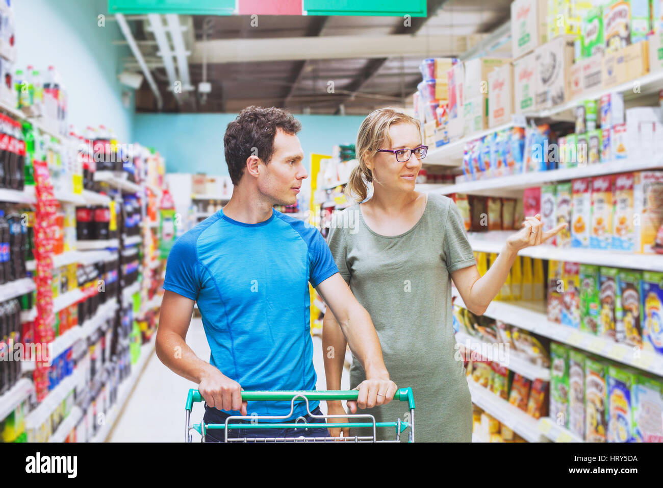 Matura in un supermercato, giovane uomo e donna shopping cibo Foto Stock