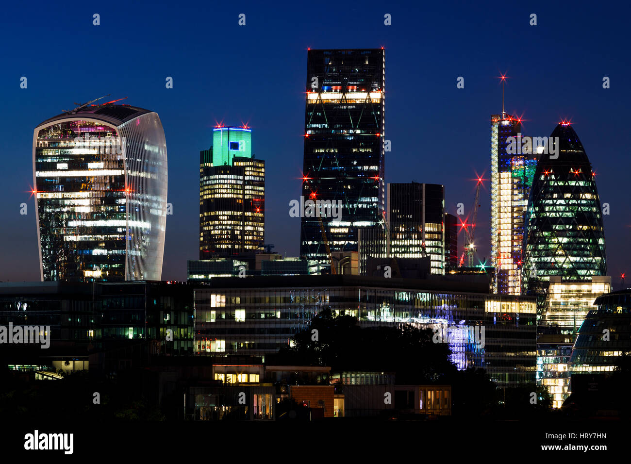 La notte skyline della city di Londra con in vista il Gherkin, London, Regno Unito Foto Stock