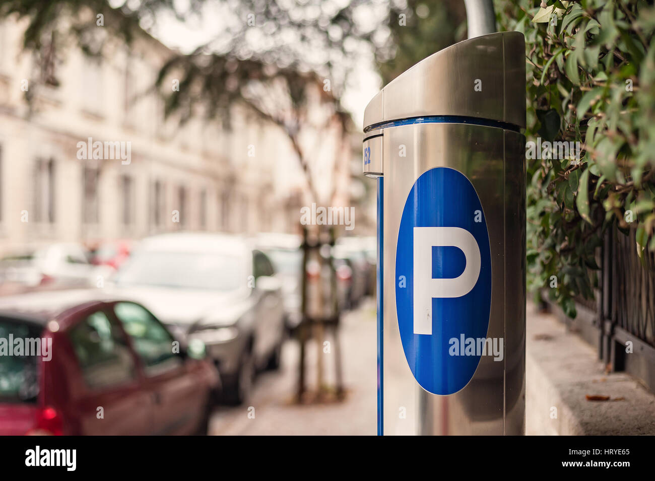 Biglietteria Automatica parcheggio su una strada di città con vetture sfocata. Segno blu del parcheggio auto. Foto Stock