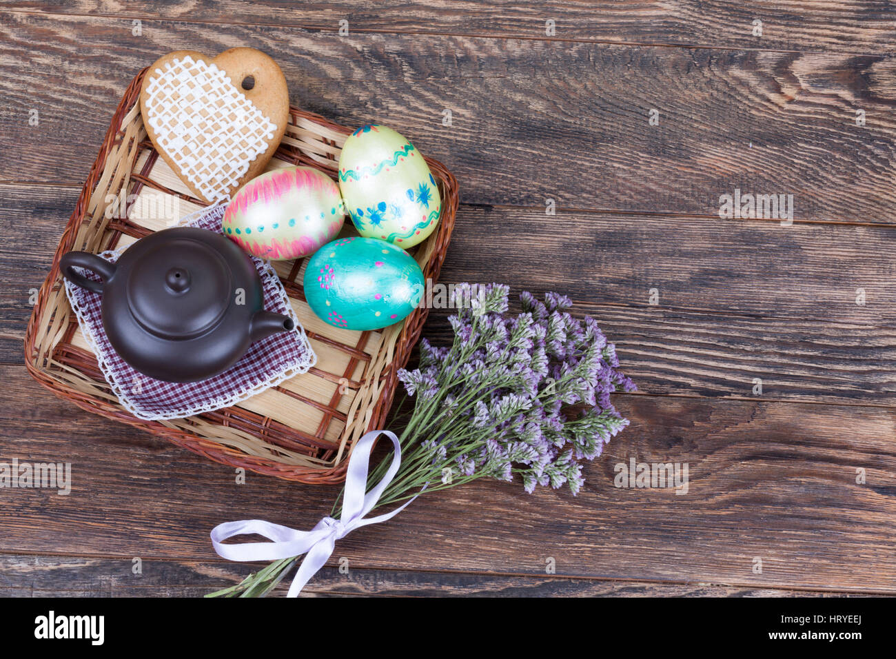 Decorazioni colorate Uova di Pasqua wirh fiori e teiera su sfondo di legno Foto Stock