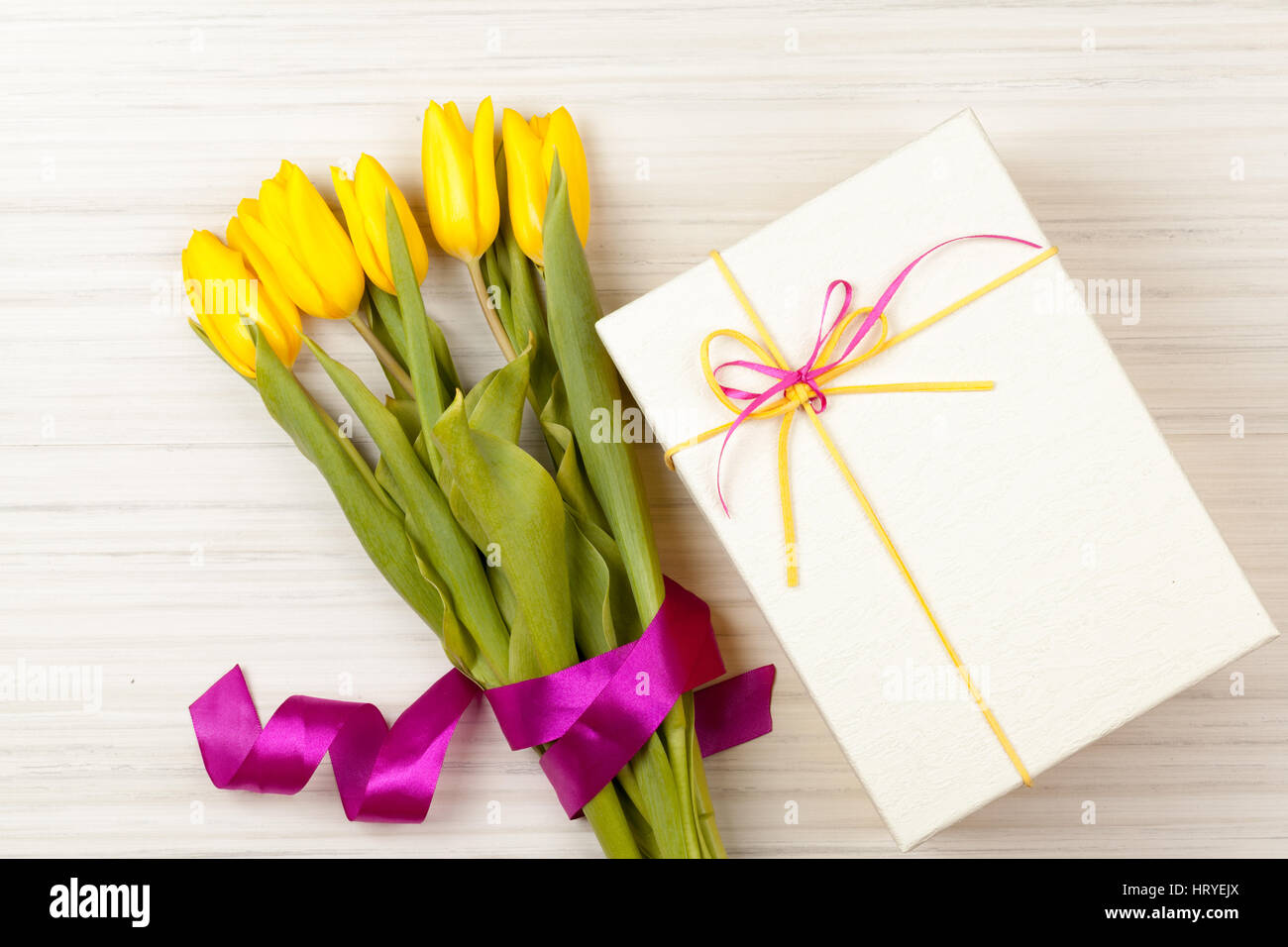 Romantico bouquet di tulipani gialli e scatola regalo bianca con giallo e rosa nastri Foto Stock