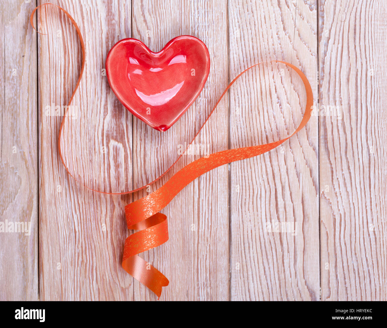 A forma di cuore ad regalo di San Valentino con nastro su sfondo di legno Foto Stock
